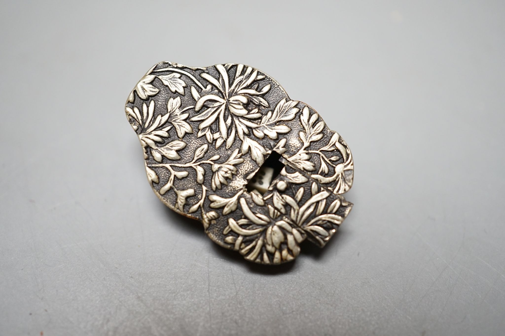 An unusual Japanese mixed metal noh mask containing minute bone dice and a stag antler noh mask brooch, signed, 3.5cm